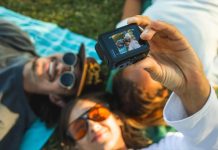 GoPro camera being handheld to capture a selfie of three people