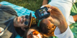 GoPro camera being handheld to capture a selfie of three people