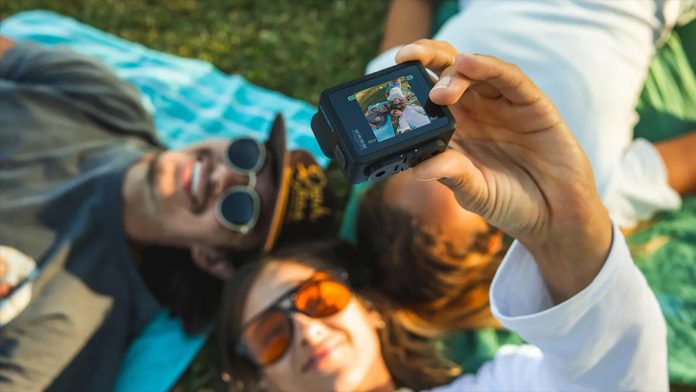 GoPro camera being handheld to capture a selfie of three people