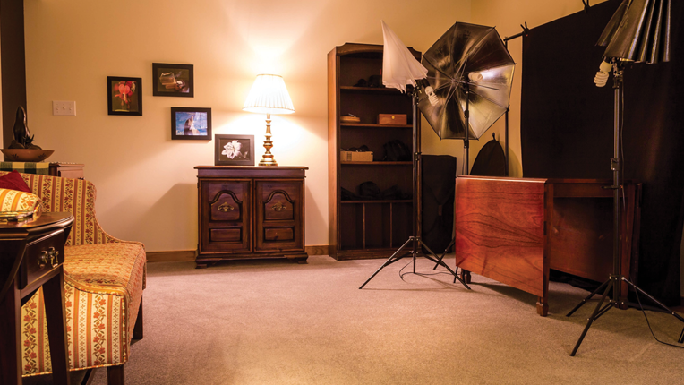 Studio set up with furniture, lamp and artwork on the walls. 