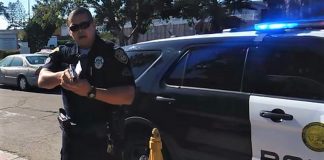 Officer James Everette pointing his gun at a videographer